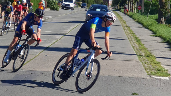 Max Herrmann de l'équipe Heizomat powered by Kloster Kitchen sur son vélo, il est en train de prendre un virage, d'autres cyclistes le suivent.
