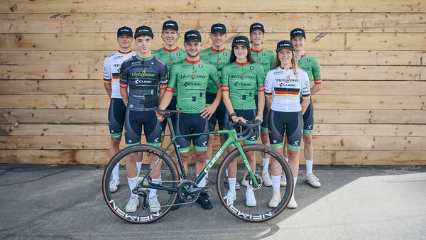 The Heizomat team powered by Kloster Kitchen 2023/2024: The team stands collected in front of a wooden wall. 