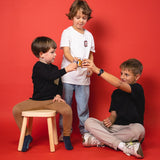 Trois garçons trinquent chacun avec un shot de fruits 1SHOT dans un flacon de 30 ml.