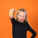Lo shot di frutta 1SHOT di Kloster Kitchen in un flacone da 30 ml è tenuto in mano da una ragazza che ammicca alla telecamera.