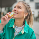 Contenu du kit de dégustation de gingembre L : une femme porte à ses lèvres un shot de gingembre classique en flacon de 30 ml.