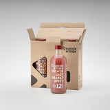 3x 12SHOTS 360 ml Ingwer Shot Granatapfel: eine der Flaschen steht vor der Verpackung, die anderen beiden Ingwer Shot Granatapfel sind noch in der Verpackung.