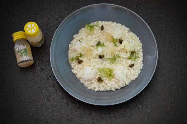 Fennel risotto served in a blue plate with two Kloster Kitchen Ginger Shots Classic next to it