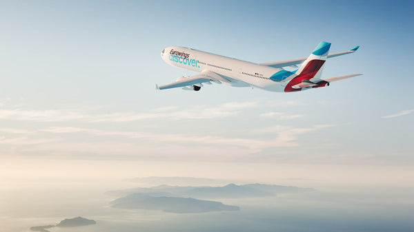 Ein Flugzeug der Eurowings Discover fliegt zwischen Wolken.