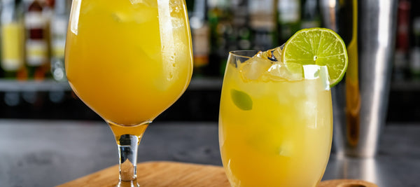 Two glasses filled with the drink "Exotic Ginger Twist". The glasses are decorated with a slice of lime.