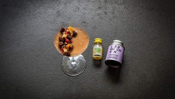 Lebkuchen Ingwer Mousse mit Winterragout angerichtet in einem Glas, daneben ein kleiner Ingwer Shot sowie Lebkuchengewürz in der Dose.