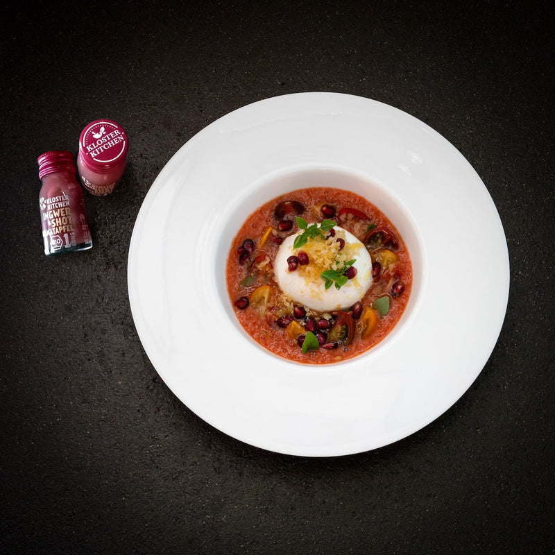 Soupe de burrata et de tomates à la grenade - à côté se trouvent deux shots de gingembre à la grenade 1SHOTs