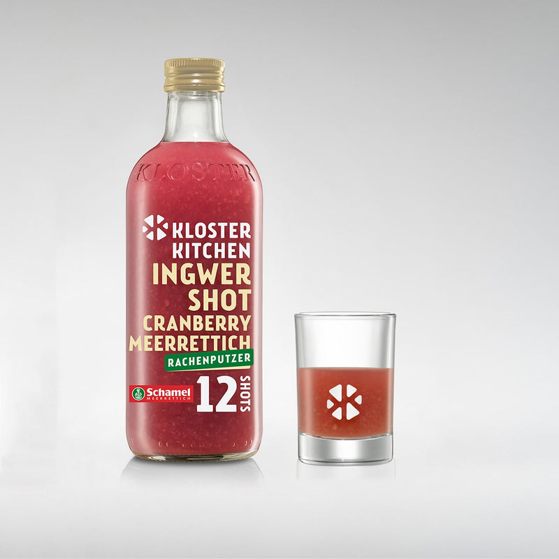 Der Ingwer Shot in der Geschmacksrichtung Cranberry Meerrettich in der 360 ml Flasche mit einem gefüllten Shot Glas daneben