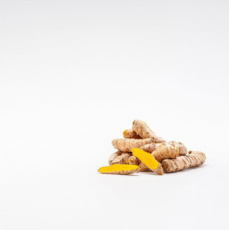 Un ingrediente del ginger shot nel gusto curcuma: un mazzetto di radici di curcuma.