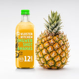A ginger shot pineapple 12SHOTS (360 ml bottle with 12 servings) next to it a pineapple