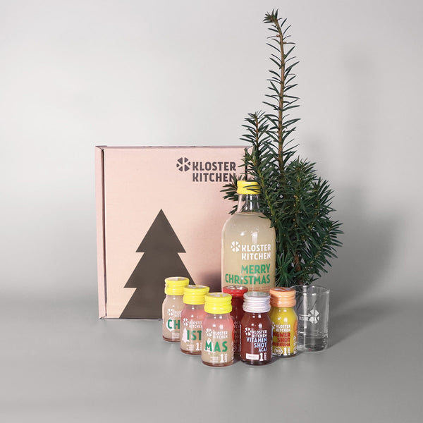 Ingwer Shot Geschenkbox Weihnachten: Box steht da, Inhalt davor aufgestellt: 1x Ingwer Shot Classic 360 ml im XMAS Design, 3x Ingwer Shot Classic 30 ml im XMAS Design, 1x Ingwer Shot Kurkuma 30 ml, 1x Ingwer Shot Granatapfel 30 ml, 1x Ingwer Shot Acai 30 ml