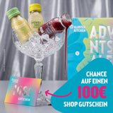 Kloster Kitchen Aktionsbild mit Ingwer Shot Classic und Vitashot in Glasschale auf Eis, daneben Adventskalender-Verpackung und ein bunter 100-€-Gutschein, Text: Chance auf einen 100 € Shop Gutschein.