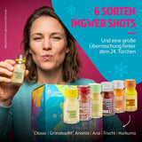 Kloster Kitchen Ingwer Shots Frau die Trinkt Adventskalender mit 6 Sorten: Classic, Granatapfel, Ananas, Acai, Frucht und Kurkuma in kleinen Glasfläschchen mit farbigen Deckeln und Bio-Siegel.
