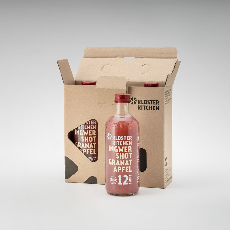  3x 12SHOTS 360 ml Ingwer Shot Granatapfel: eine der Flaschen steht vor der Verpackung, die anderen beiden Ingwer Shot Granatapfel sind noch in der Verpackung.