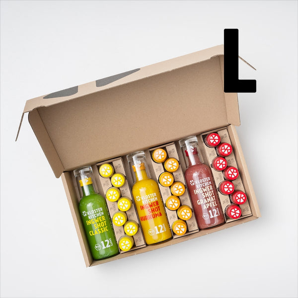 Ingwer Shot Probierset L offen, damit man den Inhalt sieht: 1x 360 ml Ingwer Shot Classic + Shot Glas, 1x 360 ml Ingwer Shot Kurkuma + Shot Glas, 1x 360 ml Ingwer Shot Granatapfel + Shot Glas, 7x Ingwer Shot Classic 30 ml, 7x Ingwer Shot Kurkuma 30 ml, 7x Ingwer Shot Granatapfel. Ein großes L daneben steht für die Größe des Probiersets.